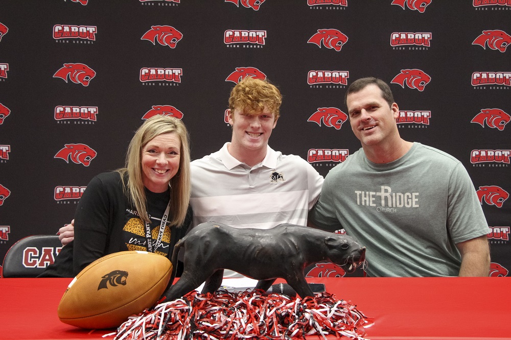 Justin with proud parents at football signing day